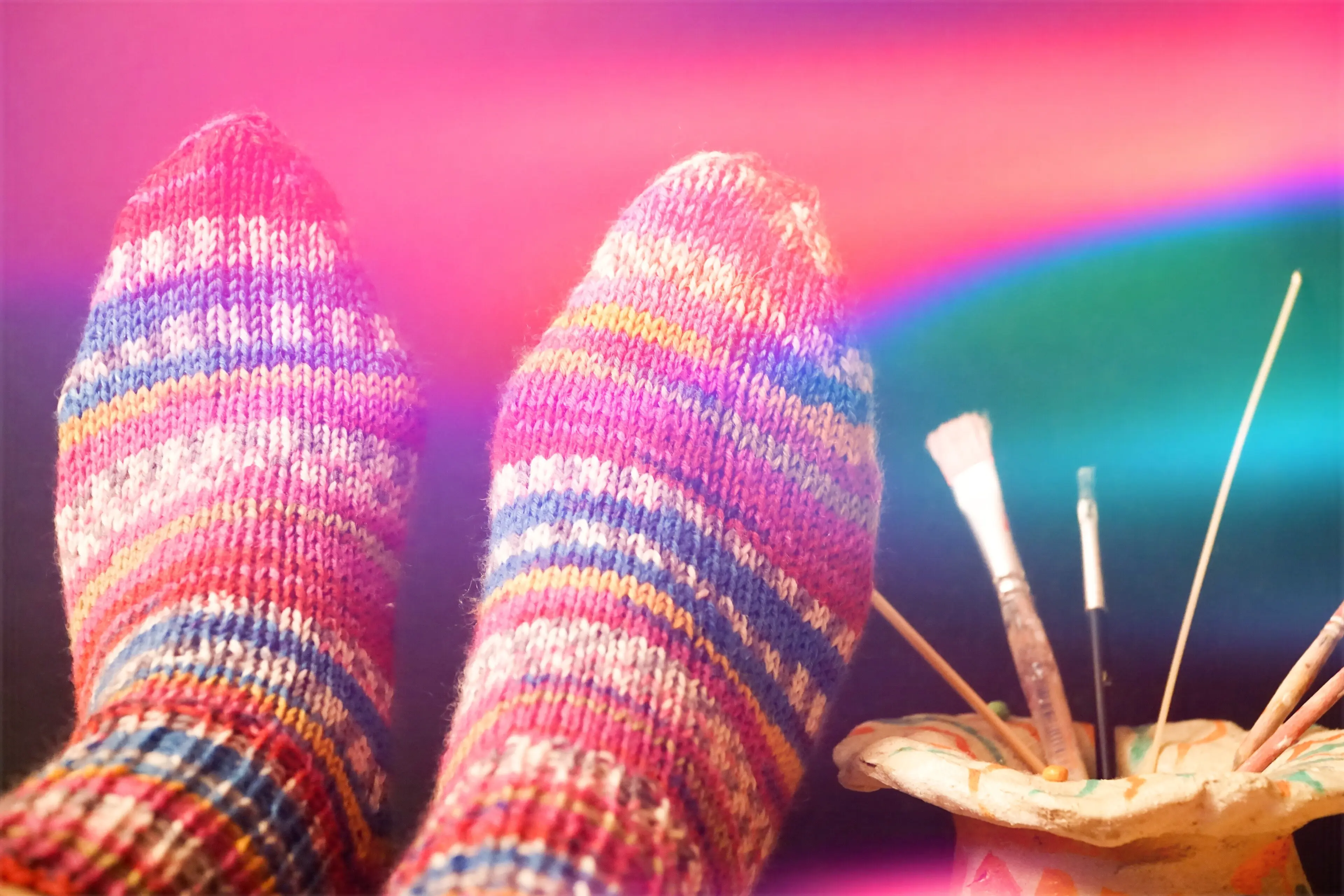 Unterer Bereich einer Person, die mehrfarbige Socken trägt.